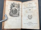 an old book with a key on top of it sitting on a table