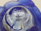 a close up view of a glass vase with a blue flower inside of it