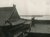 a black and white photo of a building with a lake in the background