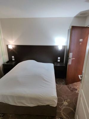 a bed that is in a small room with a big bed