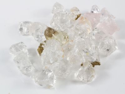 quelques cristaux blancs et roses reposent sur une surface blanche