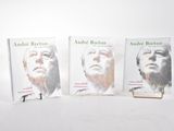 trois livres sont posés les uns à côté des autres sur une surface blanche