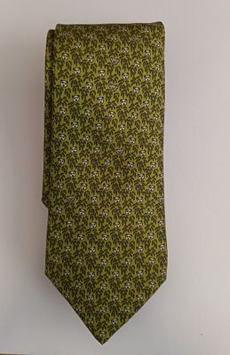 green and purple floral tie hanging on a white wall