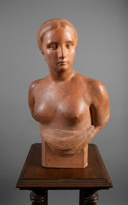 une sculpture représentant le buste d'une femme, posée sur une table en bois