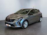 Une voiture grise est garée dans une pièce aux murs blancs.