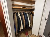 a closet with a lot of clothes hanging in it