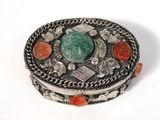 an image of a silver box with a green stone in the center