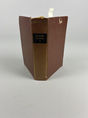 un livre marron avec des bordures dorées et une étiquette noire dessus