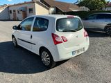 a small white car parked in a lot next to a house