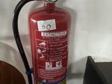a fire extinguisor sitting on a table next to a chair