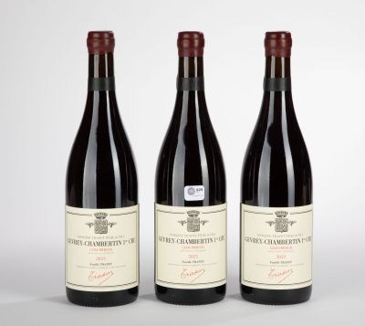 three bottles of red wine sitting on top of a white table