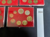 three red boxes with gold coins are on a black surface