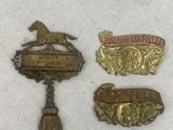 three metal badges are sitting on a white surface