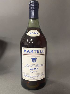 une bouteille de vin posée sur une table à côté d'un saladier