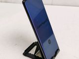 a close up of a cell phone on a stand on a white surface