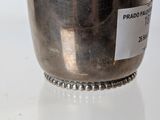 a silver cup with a label on it sitting on a table