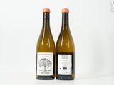 deux bouteilles de vin posées l'une à côté de l'autre sur une surface blanche
