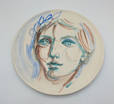 une assiette sur laquelle est représenté le visage d'une femme