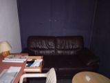 a brown leather couch sitting in a room next to a table