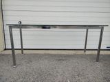 a metal table with a glass top in front of a garage door