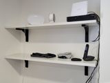 a white toilet sitting in a bathroom next to a wall mounted shelf