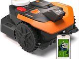 une photo d'une tondeuse robotisée avec un téléphone portable à côté