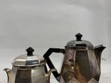 a silver tea pot and a silver teapot on a table