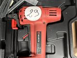 une perceuse filaire rouge dans une boîte avec d'autres outils
