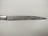 a knife with writing on it sitting on a table