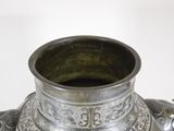 a silver vase that is sitting on a table
