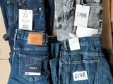 trois paires de jeans pour homme posées sur un carton