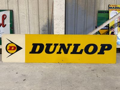 a yellow sign that says dunlop on the side of a building