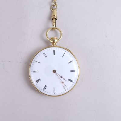 une montre de poche en or avec des chiffres romains