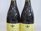 two bottles of red wine sitting next to each other on a table