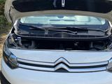 a white citrole parked on the side of the road with its hood open