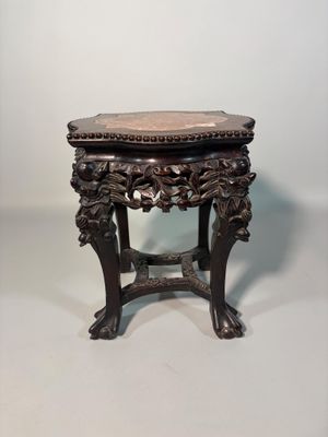an antique wooden table with a marble top on a white background