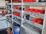 many shelves with red buckets on them in a garage