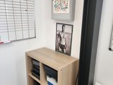 an image of a room with a desk and pictures on the wall