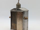 une petite cage à oiseaux en métal sur laquelle est perché un oiseau