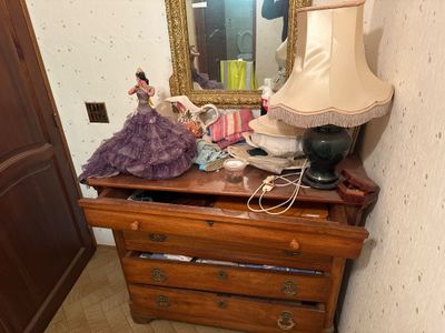 a dresser with a lamp on top of it in a room