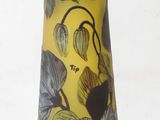 a yellow vase with black and white flowers on it