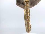 a close up of a gold bracelet on a piece of wood