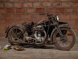 a old motorcycle that is parked in front of a brick wall