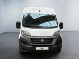 the front of a white van parked inside of a building
