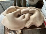 concrete sculpture of a woman ' s head on a table in a workshop