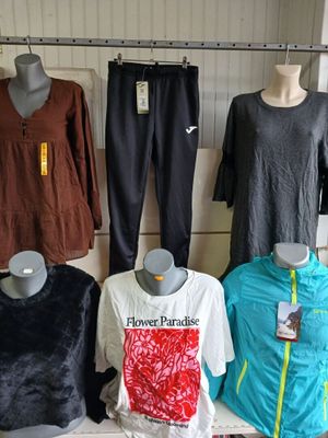several mannequins are lined up on a shelf in a clothing store