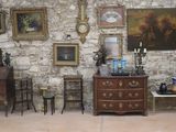 une pièce remplie de meubles anciens et de tableaux accrochés aux murs