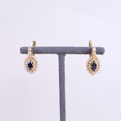 a pair of gold earrings with sapphire stones and pearls