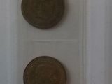 five coins in a clear box on a table