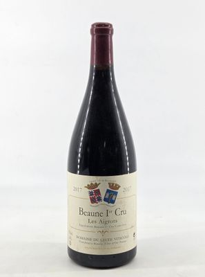 the bottle of red wine is sitting on a white surface